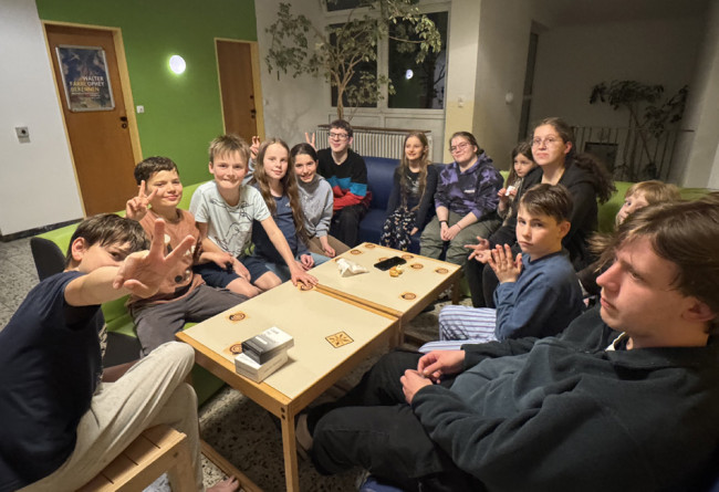 Kinder bei der Kinderfreizeit: sitzen um einen Tisch beim Spielen