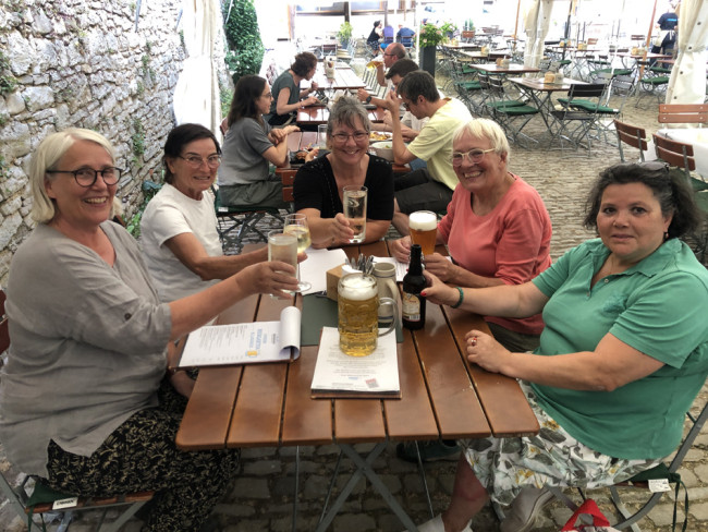 Ein Teil der Wandergruppe am Tisch im Biergarten beim Schlusshock.