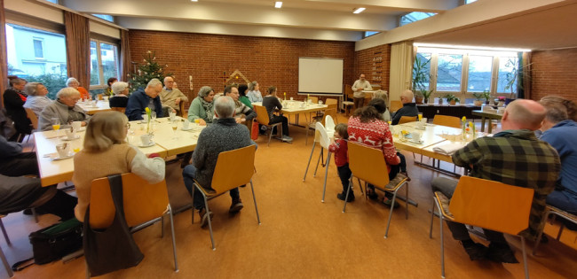 An den Tischen im Gemeindesaal Erlöser sitzende Menschen beim Dank an die Mitarbeitenden der Kirchengemeinde...