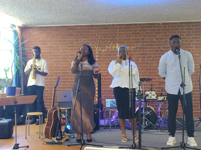 Drei Sänger:Innen und ein Saxoghonspieler beim Gottesdienst der Redeemed Christian Church of God
