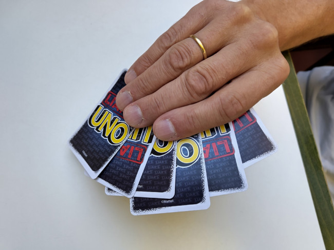 Karten des Spiels Lügen-UNO in einer Hand